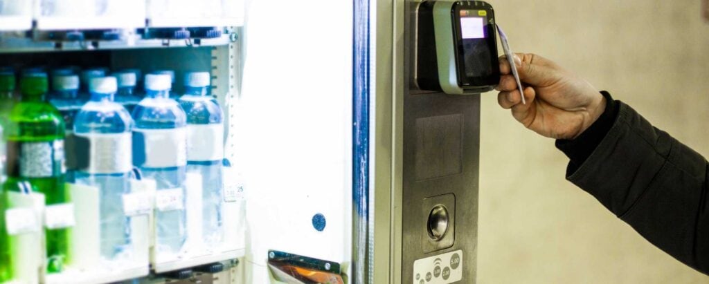 a person paying with a card at a vending machine