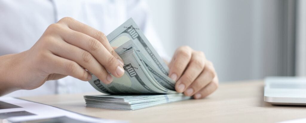 a person holding a stack of money