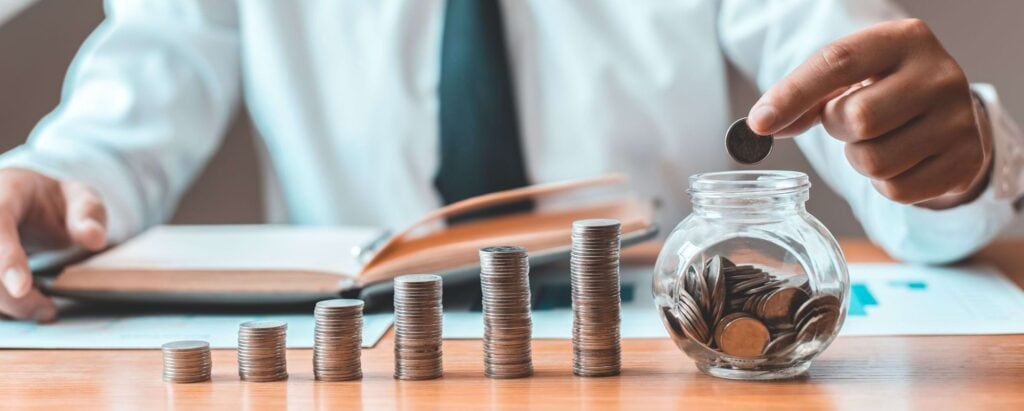 a man putting coins in a jar