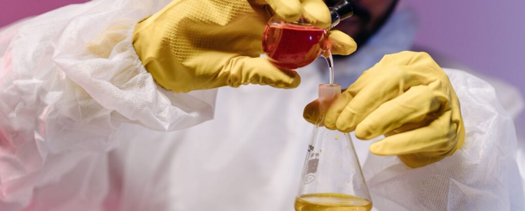 a man in a lab suit mixing chemicals

