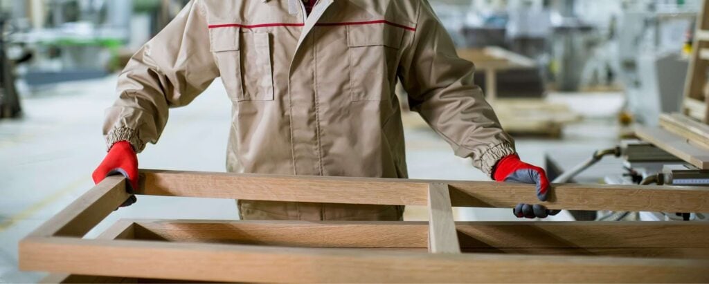 a person working with a wooden frame, building furniture