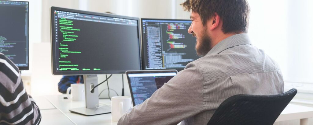 a software engineer looking at computer monitors
