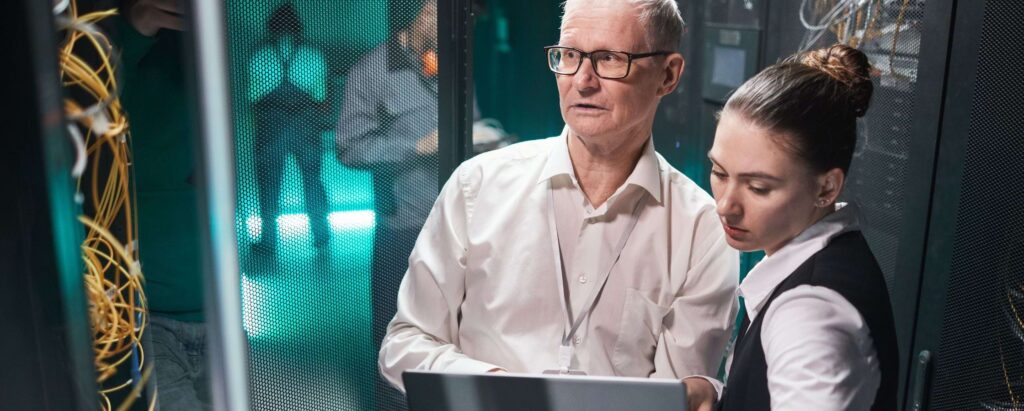 two data scientists standing in front of server racks