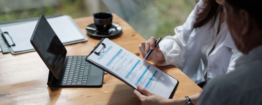 a health insurance worker showing a health insurance form to a customer