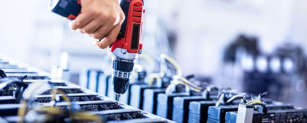 a person drilling materials in a factory