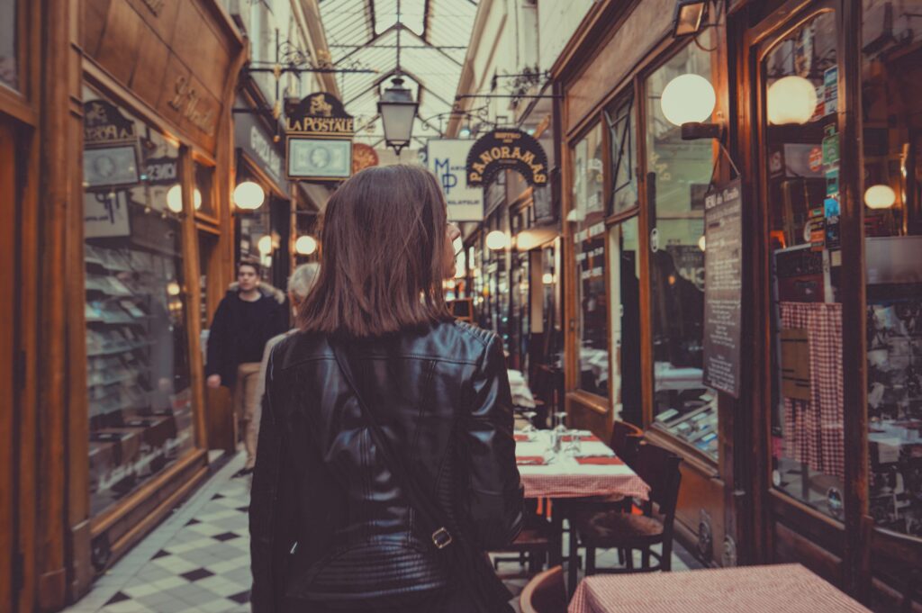 a woman walking along a group of retailers 