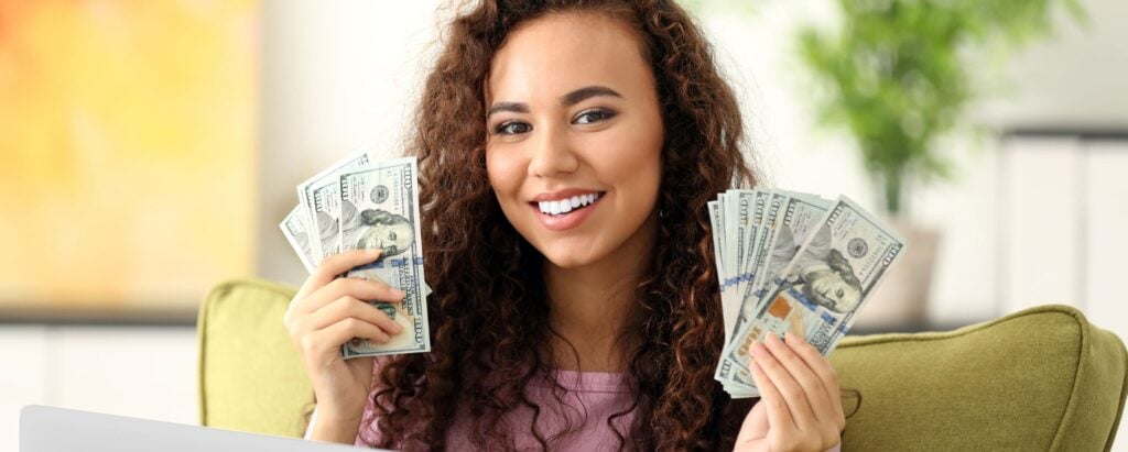 A woman holding a wad of money, getting paid for searching the web