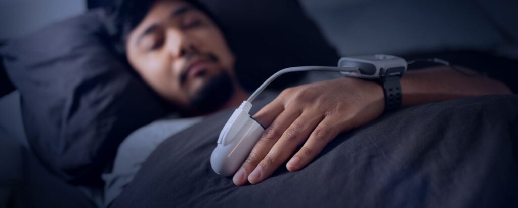 Man sleeping in bed and participating in a sleep study experiment