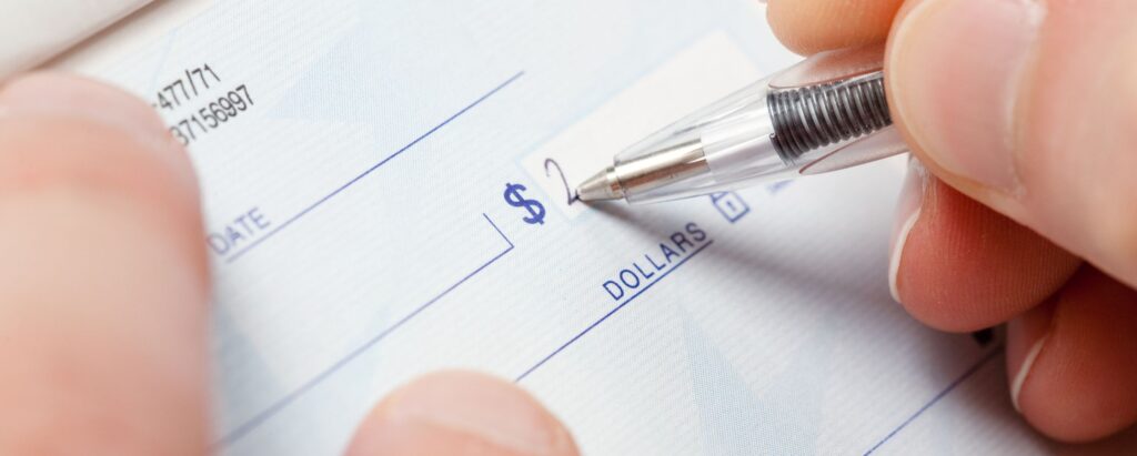 A person filling a check