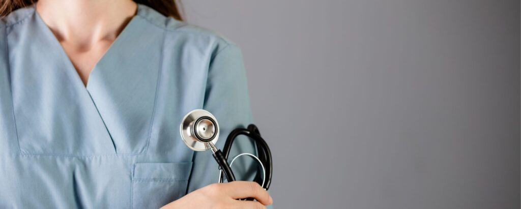 Nurse in green uniform holding stethoscope in hand