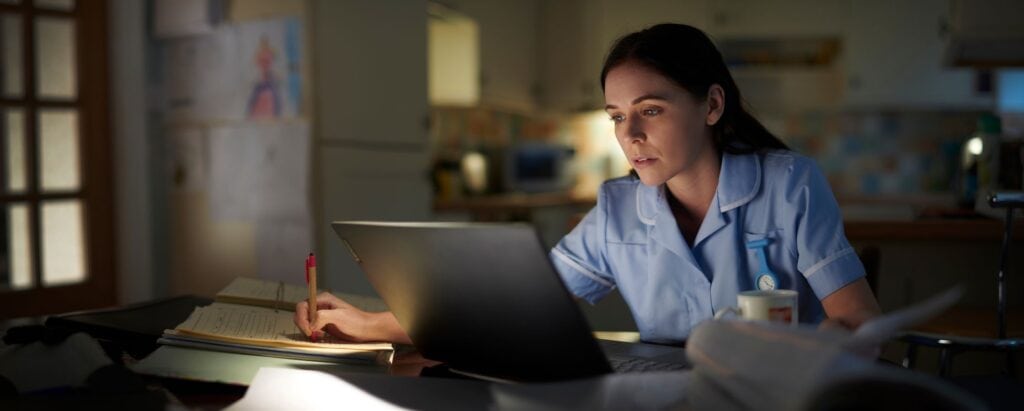 Nurse working on a laptop from her home